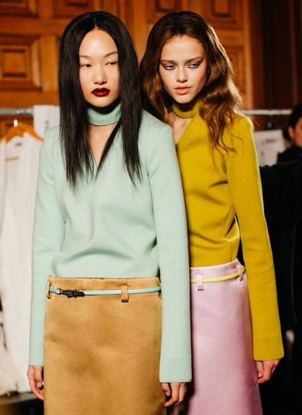 Models backstage at Marc Jacobs wearing colorful sarin skirts and longsleeve tops